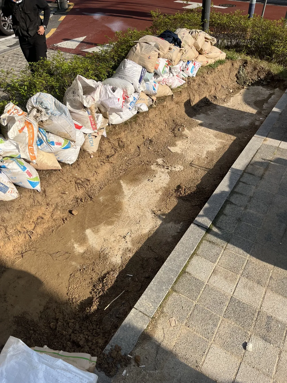보도블럭침하로 바닥이 파여 자재를 쌓아둔 굴착 현장